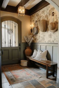 an entryway with a bench and baskets on the wall, lights hanging from the ceiling