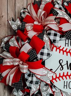 a baseball wreath with the words home sweet home on it and red, white and black ribbon