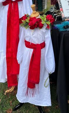 red and white wedding gowns are on display at an outdoor event in the grass