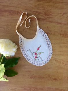 This is a pretty little handmade bib. Made from a vintage embroidered cotton doily with cotton crocheted edging . It has  cream binding ties and is backed with soft flannelette. Pretty and practical it would set off any little outfit for a special occasion, with a vintage feel . It measures approx 17 cm  long and 18 cm wide including lace trim. Please supervise baby while wearing this bib, not designed to be slept in. Ready to ship now. Thanks for looking . 😊 Cute Handmade Cotton Bib, Cute Handmade White Bib, Cute White Handmade Bib, Embroidered Cotton Bib, Material Ideas, Handmade Bib, Vintage Doily, Kids Sewing, Pixie Hat