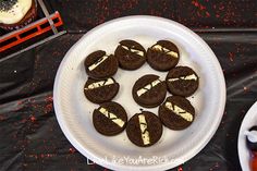 chocolate cookies with white frosting and oreos arranged on a plate next to cupcakes