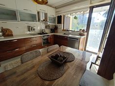 a wooden table sitting inside of a kitchen next to an open door leading to a patio