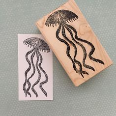 a rubber stamp with an image of a jellyfish on it next to a piece of paper