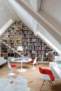 an image of a living room setting with bookshelves and chairs on the floor