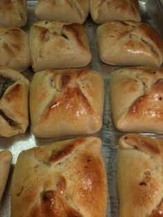 rolls are lined up on a baking sheet