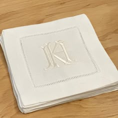 the monogrammed napkins have been folded on top of each other and are white