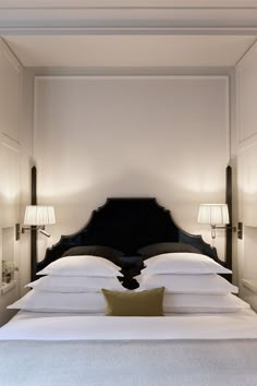 a bed with two lamps on either side of it and a white bedspread