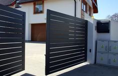 two black gates open in front of a house