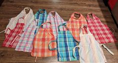 seven aprons lined up on the floor in a row