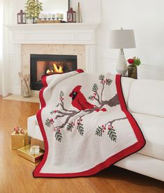 a white couch with a red cardinal afghan on it