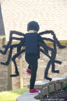 a little boy dressed up in a spider costume