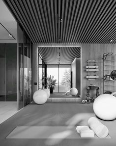 a black and white photo of a living room with yoga mats on the floor in front of large windows