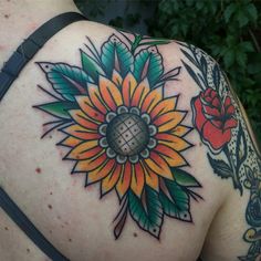 a sunflower tattoo on the back of a woman's upper arm and shoulder