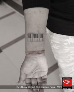 a person with a wrist tattoo that has piano keys on it