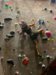 a woman climbing up the side of a rock wall