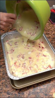 a person pouring batter into a pan on top of a counter