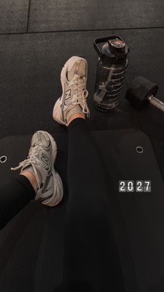 a person is sitting on a mat with their feet propped up next to a water bottle