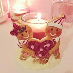 a candle that is sitting on a table next to some cookies and a cupcake