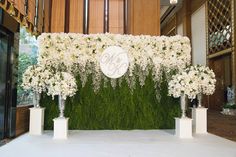 an arrangement of white flowers and greenery on display in front of a reception hall