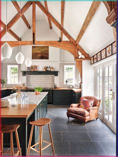 an open kitchen and living room with wood beams