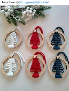 six christmas tree ornaments hanging from wooden hoops on a white table with pine branches