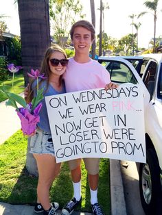 two people standing next to each other in front of a car holding a sign that says on wednesdays we wear pink now get in i'vender were going to prom