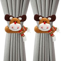 two curtains with reindeer hats and scarfs on them