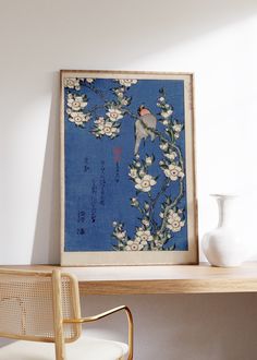 a bird sitting on a flowered branch in front of a blue background with white flowers