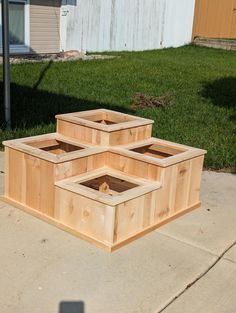 three wooden boxes sitting on top of a sidewalk