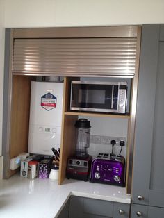 a kitchen area with a microwave, toaster oven and coffee maker on the counter