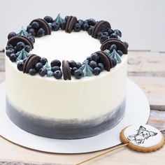 a white cake with blueberries and oreo cookies