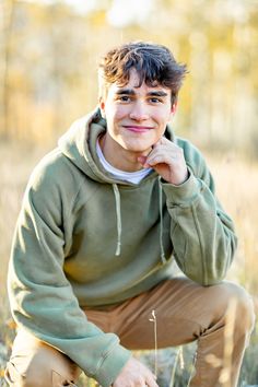 Senior boy kneels and rests his face on his hand and smiles surrounded by aspens during the fall during his senior session in Cripple Creek, Colorado with Eden's Glow Photography. Fall Senior Boy Picture Ideas, Senior Mini Sessions, Outdoor Male Senior Pictures, Boys Outdoor Senior Picture Ideas, Boy Senior Photos Nature, Senior Fall Pictures Boys, Fall Senior Boy Pictures, Fall Senior Pics For Guys, Fall Senior Photos Boys