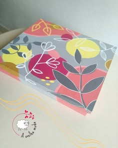 the box is decorated with colorful flowers and leaves on it's side, along with a sheep sticker