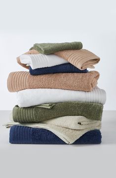 towels stacked on top of each other in various colors and sizes, all folded up