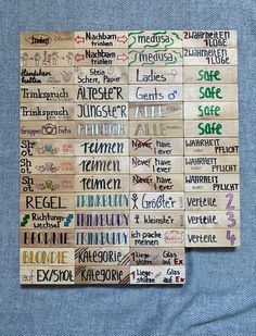 two pieces of wood with words written in different languages on them, sitting on top of a blue cloth