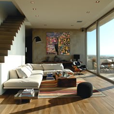 a living room filled with furniture next to a large glass window covered in lots of windows