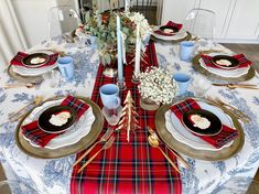 the table is set with red, white and blue place settings for christmas dinner party