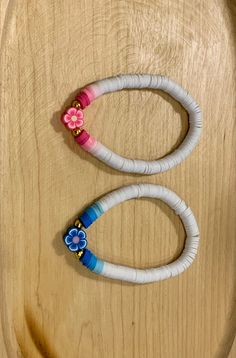 two white and blue bracelets with flowers on them