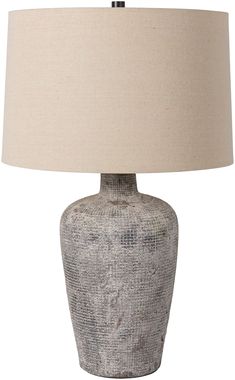 a gray table lamp with a beige shade on it's base and a white linen lampshade