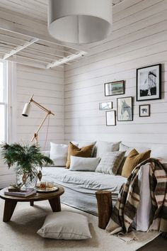 a living room filled with furniture and pictures on the wall next to a coffee table