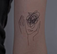 a woman's arm with an abstract tattoo on it