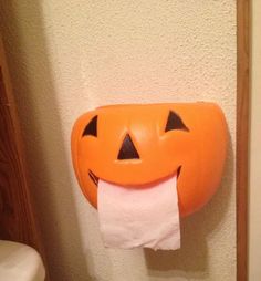 a toilet paper dispenser with a pumpkin face on it