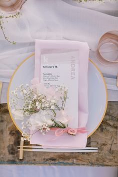 a plate with flowers on it next to napkins and other items that are sitting on the table