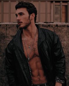 a man with no shirt standing in front of a wall