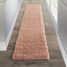 a pink rug on the floor in a hallway