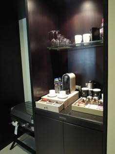 the coffee bar has two trays with cups on it, and there is also an espresso machine