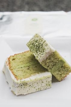 two pieces of green cake sitting on top of a white plate with a fork next to it