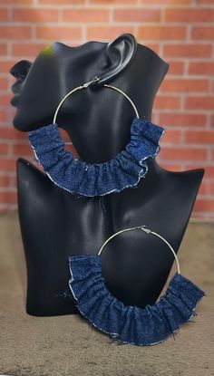 two pairs of blue denim ruffled hoop earrings sitting on top of a mannequin head