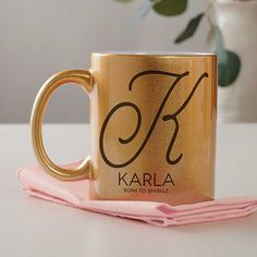 a gold coffee mug sitting on top of a pink cloth