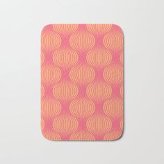 an orange and pink bath mat with circles in the middle, on a white background